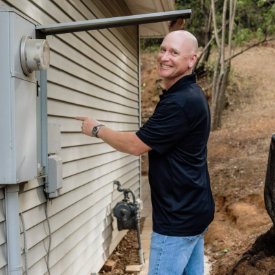 Nighthawk home inspector examining exterior electrical panel during a 1-year builder warranty inspection in Sacramento